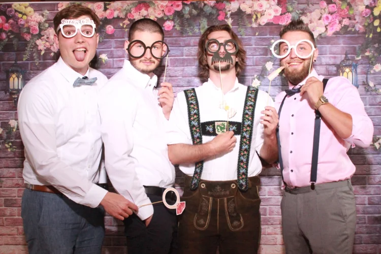 Männer posieren mit lustigen Requisiten in der Fotobox bei einer Hochzeit in Bayern