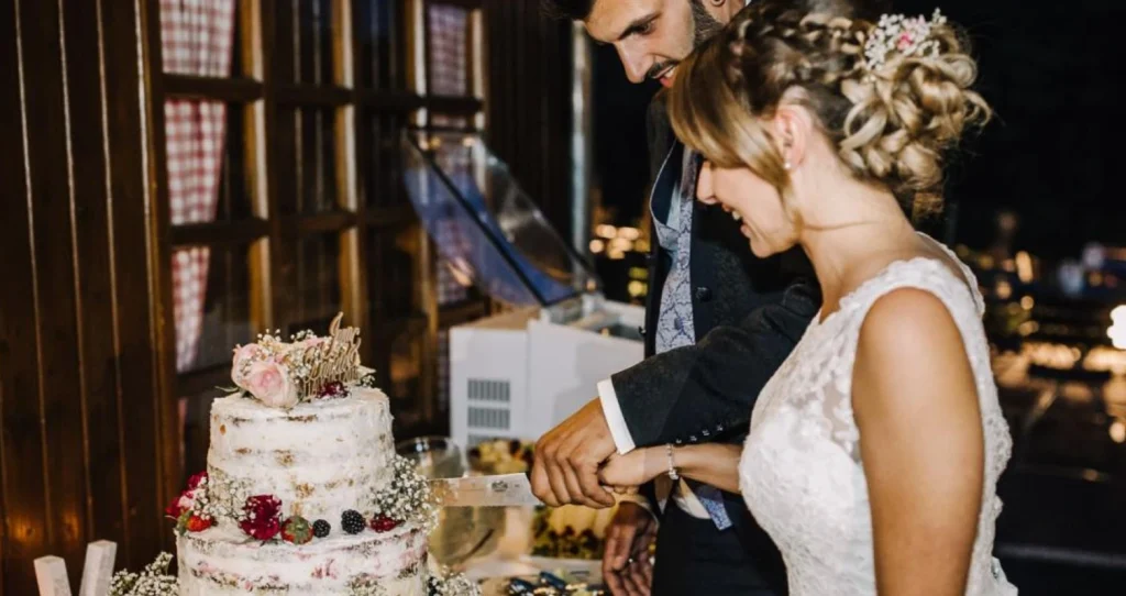 Das Brautpaar schneidet die Hochzeitstorte an.