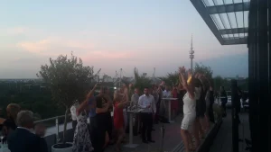 Auf der Hochzeit tanzen die Gäste auf dem Rooftop vom Weitblick in München