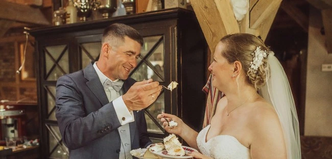 Das Brautpaar schneidet die Hochzeitstorte im Filzenklas an